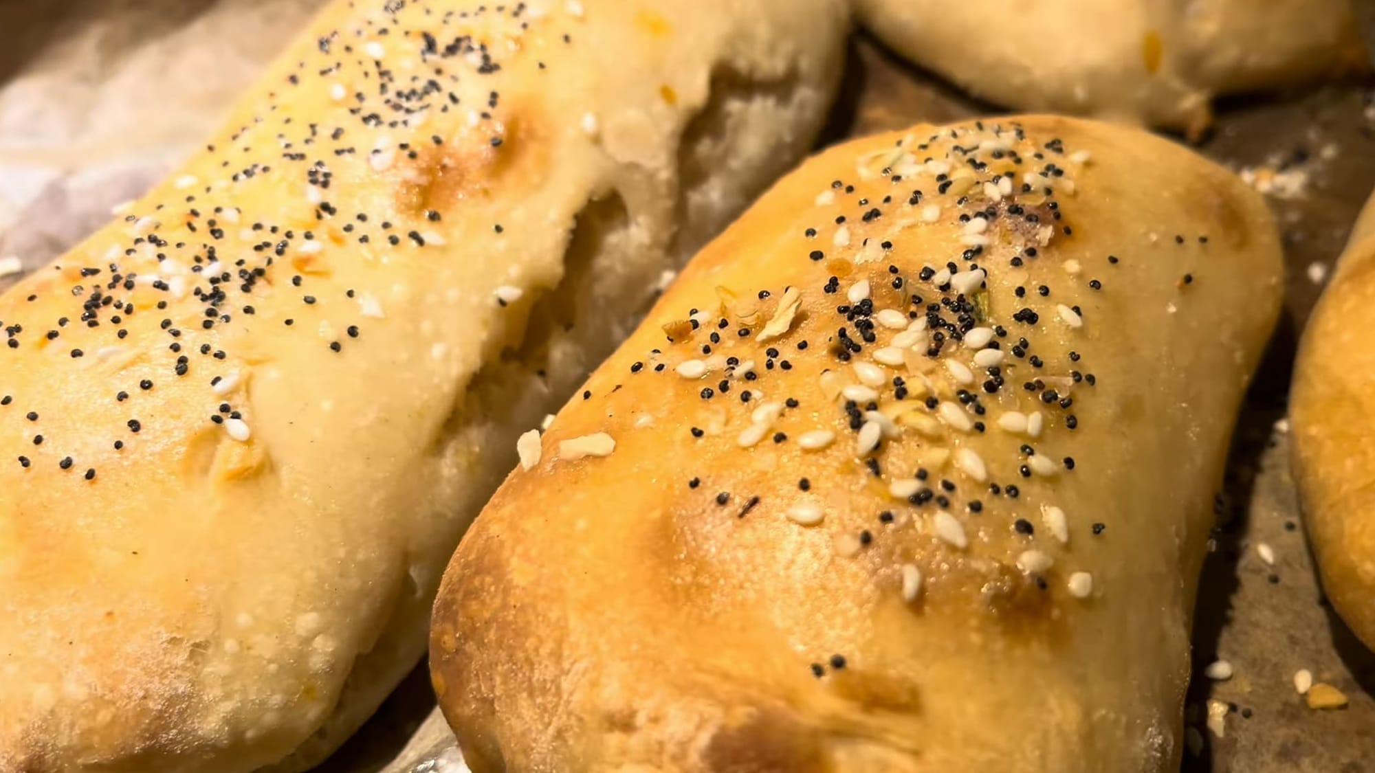 Confusingly asymmetrical, bizarre-looking rolls, haphazardly sprinkled with sesame and poppy seeds